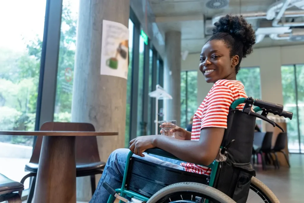 Happy disabled woman in wheelchair smiling at camera